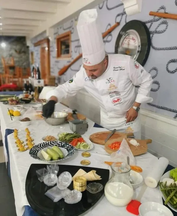 Chef durante uno show cooking con giacca ricamata